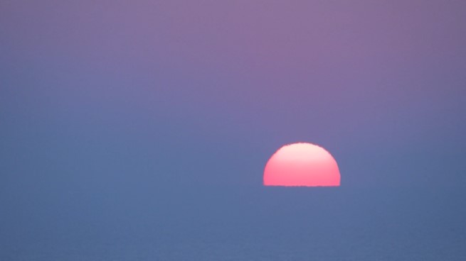 Alba con sole rosa e sfondo blu